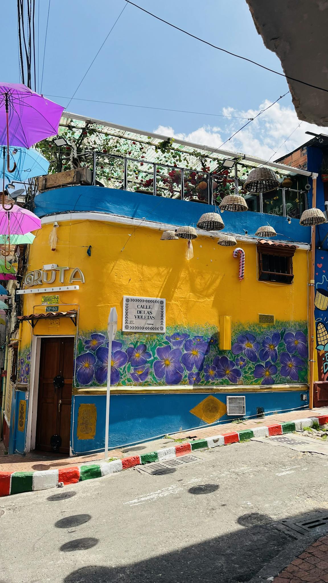 Explore a vibrant urban street with colorful buildings and artistic murals under a sunny sky. Perfect for travel and tourism themes.